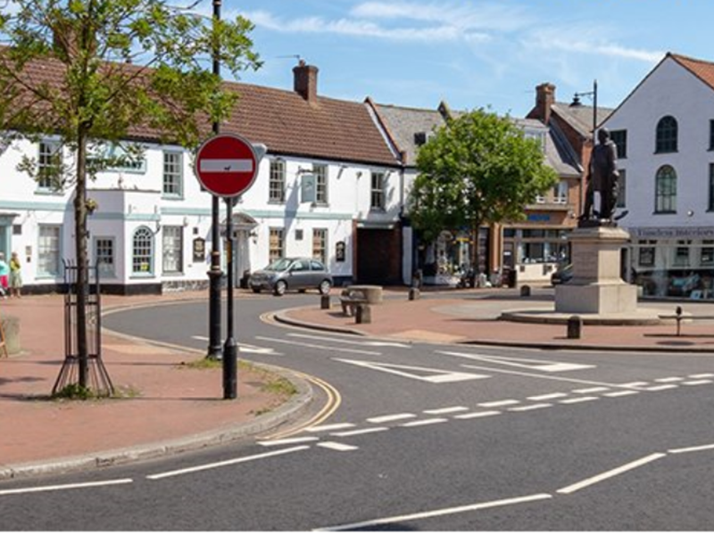 A photo of a sunny street intersection